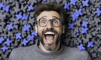 A man with glasses and a smile is surrounded by blue stars photo