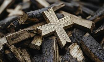 A wooden cross sits on top of a pile of wood photo