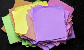 Colorful Sheets of Torn Paper Stacked on a Dark Background for Creative Projects and Design Ideas photo