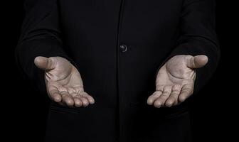 Open Hands Gesture of Hospitality and Welcome, Symbol of Acceptance and Invitation with Dark Background in Formal Attire for Business or Personal Situations photo