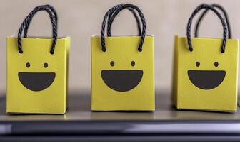 Three cheerful yellow gift bags with smiling faces arranged on a sleek surface, perfect for celebrations, parties, and joyful occasions, adding fun and excitement photo