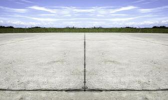 Vast Expansive Concrete Ground with Clear Blue Sky and Lush Green Grass, Ideal for Backgrounds and Texture in Scenic Photographs and Designs photo