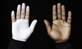 A stark contrast between a gloved hand and a bare hand against a dark background, illustrating themes of protection, identity, and tactile experience photo