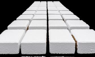 White sugar cubes arranged in a perfect geometric pattern on a black background showcasing detail, texture, and composition for culinary and food visuals photo