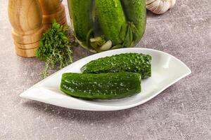 A white plate with cucumbers and garlic on it photo