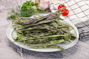 A plate of beans on a table with a knife and a knife photo