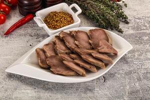 A plate of meat with spices and herbs on a table photo