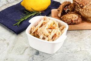 A crab and a lemon on a cutting board photo