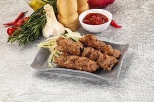 A plate with meat skewers and other ingredients photo