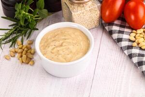 A bowl of mustard with tomatoes, nuts and herbs photo