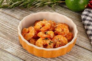 A bowl of shrimp with a garnish of herbs photo