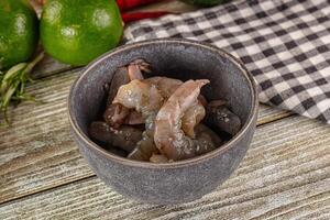 A bowl filled with meat and vegetables on a wooden table photo