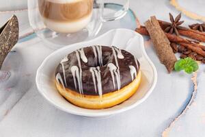 A donut with chocolate icing and cinnamon on a plate photo
