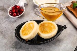 A bowl of cranberry sauce and two small pancakes on a table photo