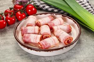 A bowl of bacon wrapped in bacon sitting on a table photo