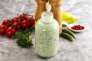 A bottle of dressing with tomatoes, peppers and other ingredients photo