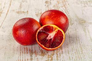 A table with two oranges and a half eaten one photo