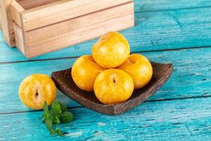 A bowl of fruit on a wooden table photo