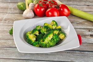 A white plate with broccoli and tomatoes photo