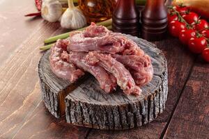 Raw meat on a wooden table with vegetables and spices photo