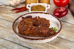 A plate with a piece of meat on it and some spices photo