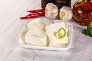 A bowl of white cubes with a green leaf on top photo