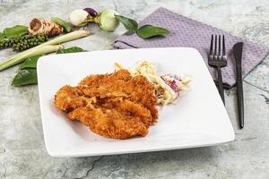 Fried chicken on a plate with vegetables and a fork photo