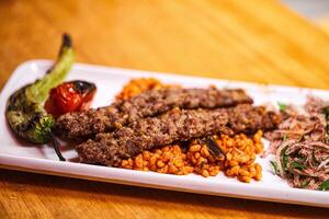 A plate with meat, rice and vegetables on it photo