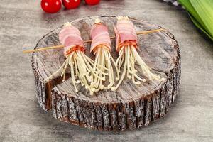 Three pieces of bacon on a wooden log photo
