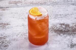 A red drink with an orange slice on top photo