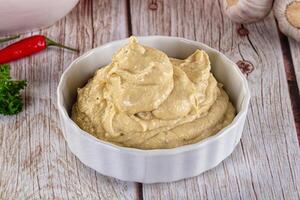 A bowl of hummus with garlic and parsley photo