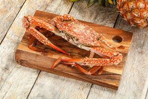 A crab on a cutting board with a pineapple and a pineapple photo