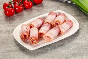 A plate with bacon wrapped in ham on it photo