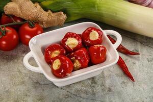 A white bowl filled with red peppers and garlic photo