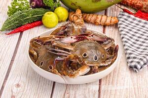 A bowl of crabs on a table with a knife and a knife photo