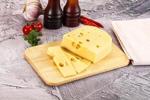 A cheese board with a slice of cheese and a bottle of ketchup photo
