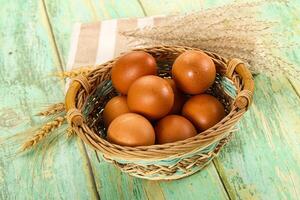 A basket of brown eggs on a wooden table photo