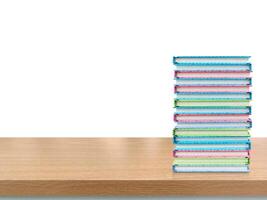 Stack of books on wooden table, isolated on white background. photo