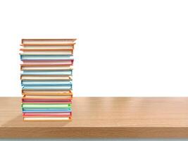 Stack of books on a table with white background. Stack of colorful books on a wooden table. photo