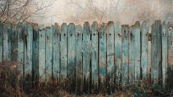 Old, Weathered, Blue Wooden Fence With a Misty Background of Trees photo