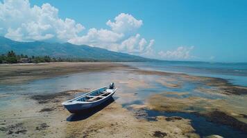 Lone Blue Boat on a Sun Drenched, Tranquil Beach With Mountains In the Distance photo