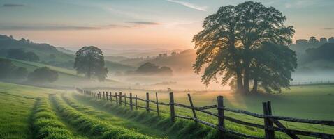 Serene Sunrise Over Rolling Fields with Wooden Fence and Misty Landscape Capturing the Beauty of Nature and Tranquility in a Rural Setting. photo