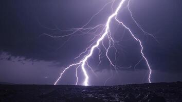 Lightning strikes over a dark sky with a large mountain in the background photo