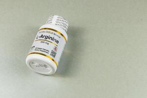 Lviv Ukraine 10.04.25 L arginine supplement bottle on a gray surface photo