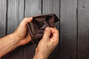 Despair in finance as businessman examines empty wallet amidst economic crisis photo
