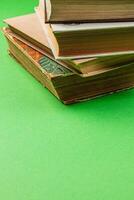 Stack of vintage books resting on green background in a cozy atmosphere photo