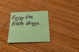 Motivational note about appreciating small joys on a bamboo mat photo