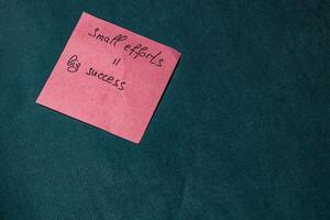 Inspirational note on a pink sticky notepad on a green background photo