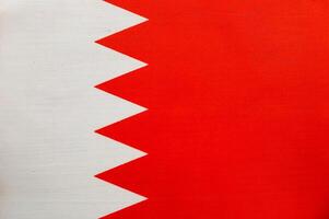 Bahrain national flag displayed against a blue background photo