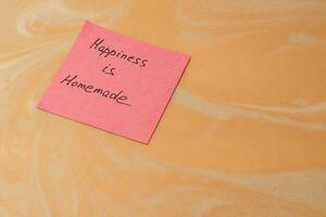Note expressing a heartfelt sentiment about homemade happiness on a surface photo